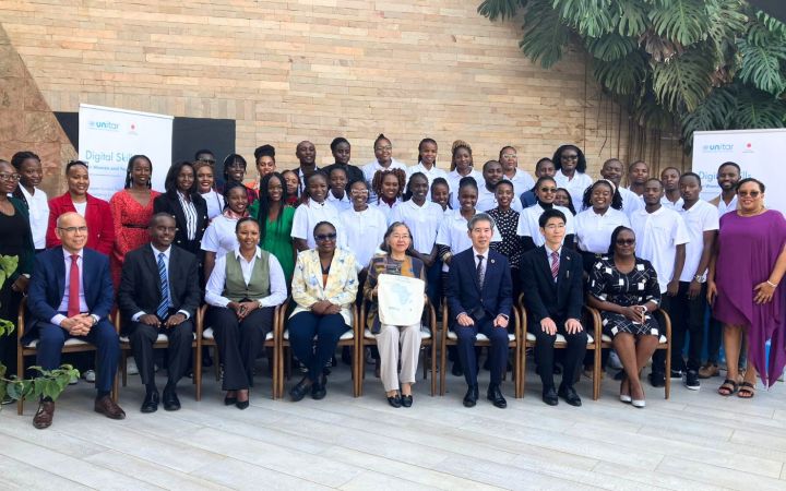 Group photo of mostly African young professionals, women and men, standing in three rows. Eight officials are seated in front, a mix of African and East Asian men and women.
