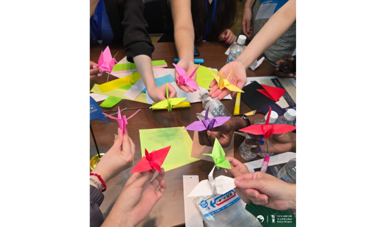 Hands holding colorful paper cranes