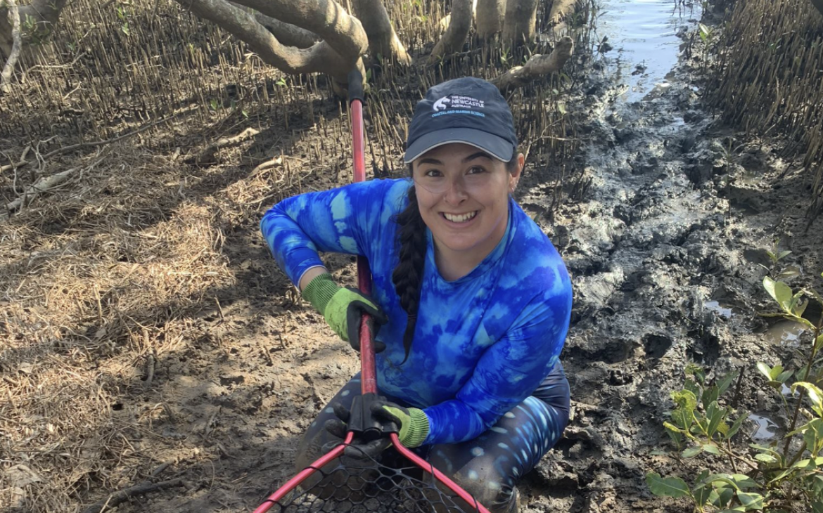 SDG14 PhD Student Molly Grew holding a stingray in a net at Brisbane Water