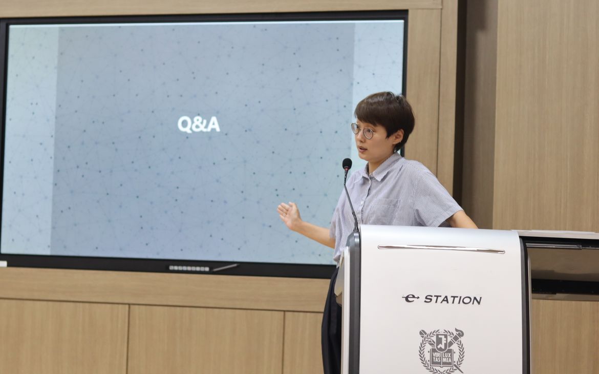 Dr. Sujeong Choi presents in front of the stage. 