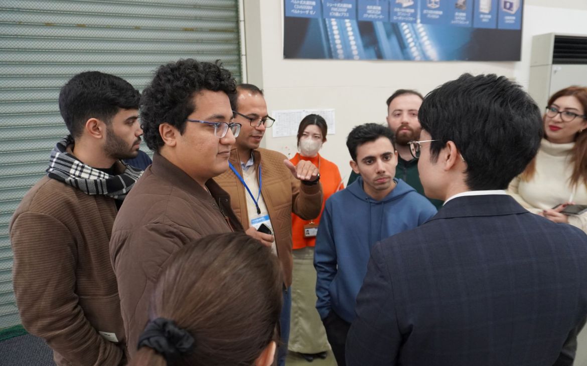 A person with brown jacket speaking in a group in a building.