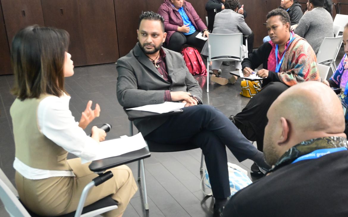 A group of four, sitting in a circle and discussing for a training programme
