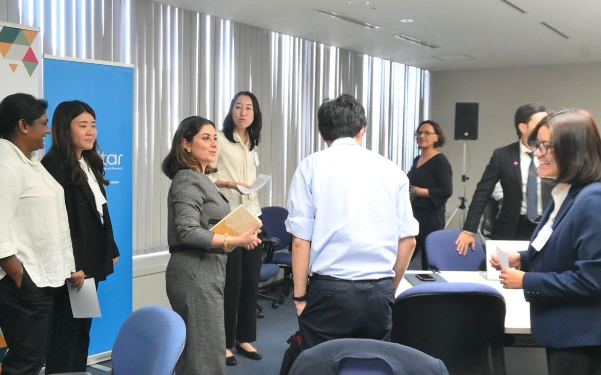 A group of participants standing and casually conversing in a room