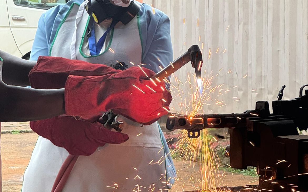 Participants dismanteling weapon with a blowtorch