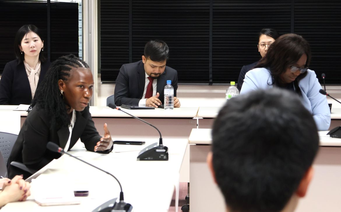 A participant sitting and speaking to fellow participants for a discussion