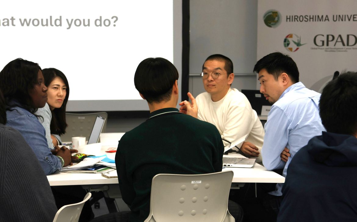 A group session being held with participants sitting in a group of four and in discussion