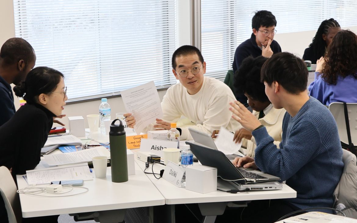 A group session being held with participants sitting in a group of four and in discussion