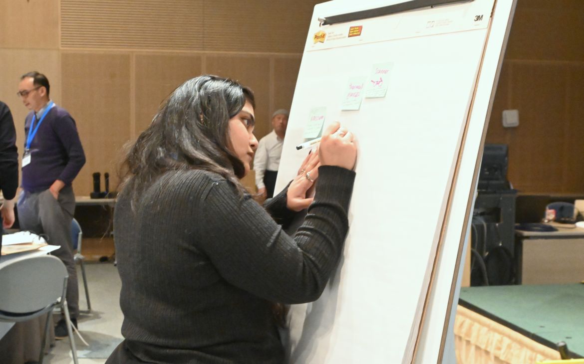 A UNITAR training programme participant using a large sketch panel to prepare for a presentation