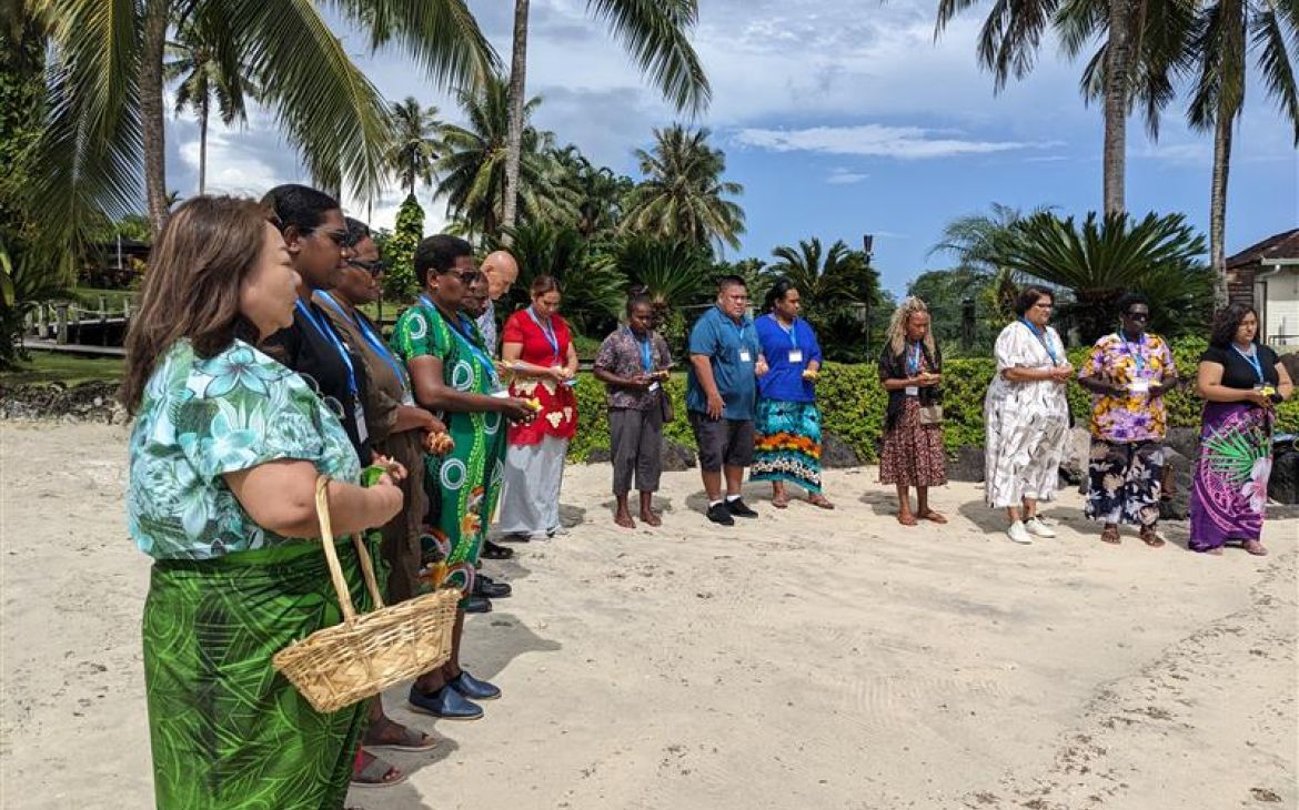 Participants conducting a flower offering by the beach as part of the study tour to commemorate the Great East Japan Earthquake and the 2009 Samoa earthquake