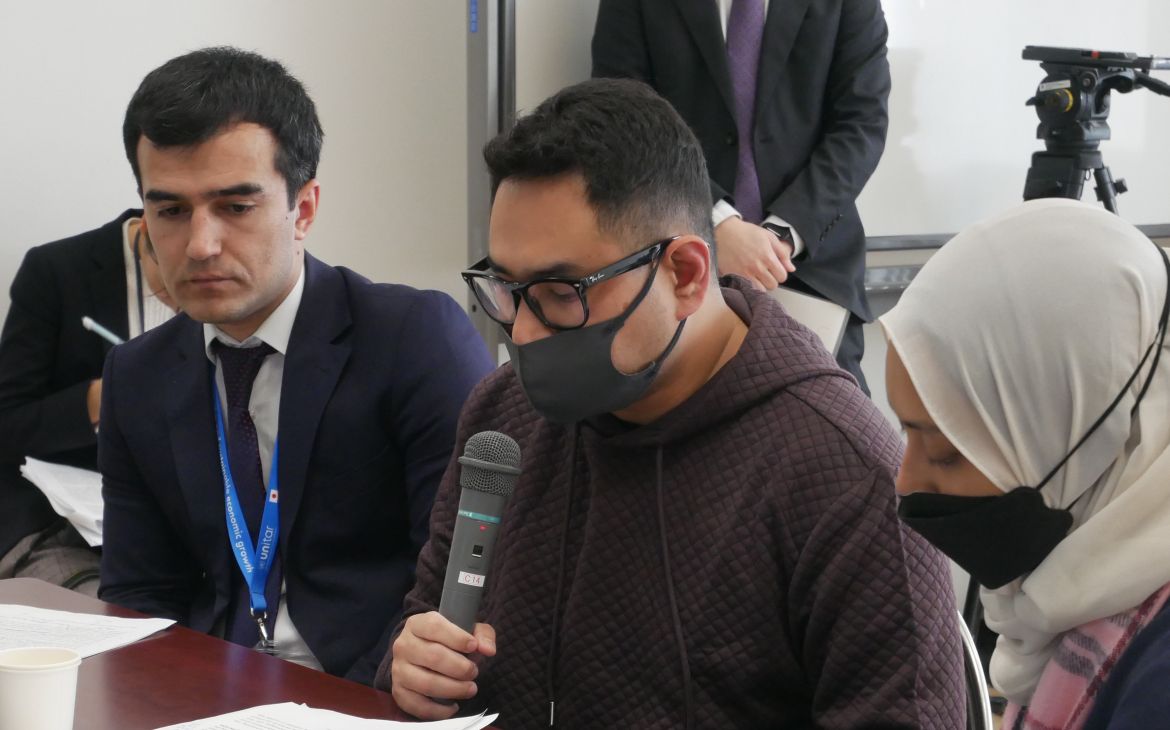 UNITAR training participant sitting and speaking during a session with a microphone
