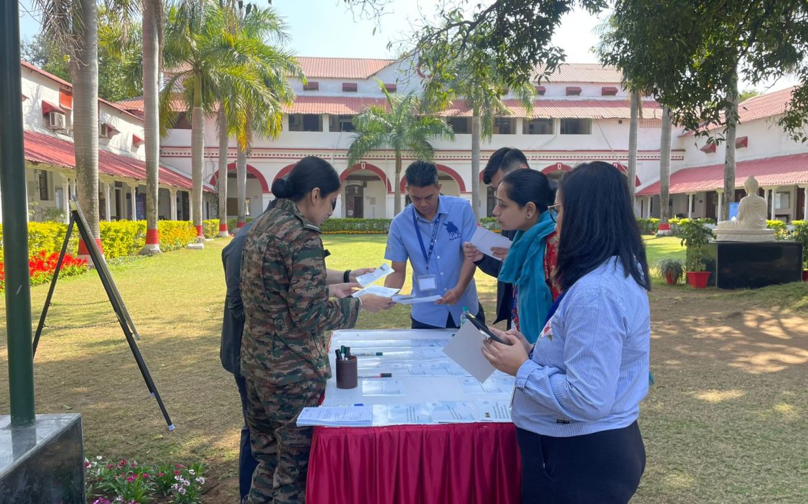 Participants gathering around the table, with papers in their hands and engaging with materials for the training. 