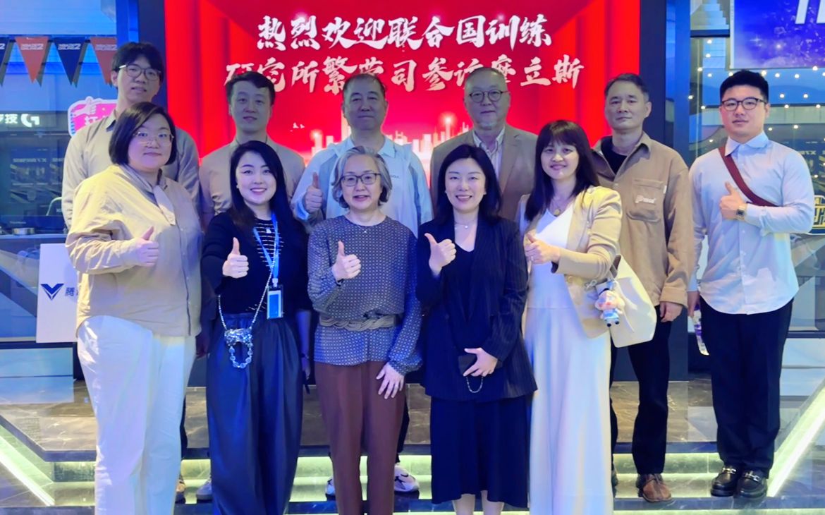East Asian men and women professionals pose with their thumbs up.