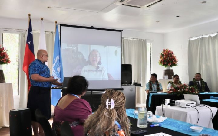 Participants sitting in a launch session, watching a speech being conducted through the screen