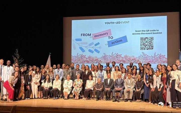 A group photo won stage with over 50 participants in front of a large screen