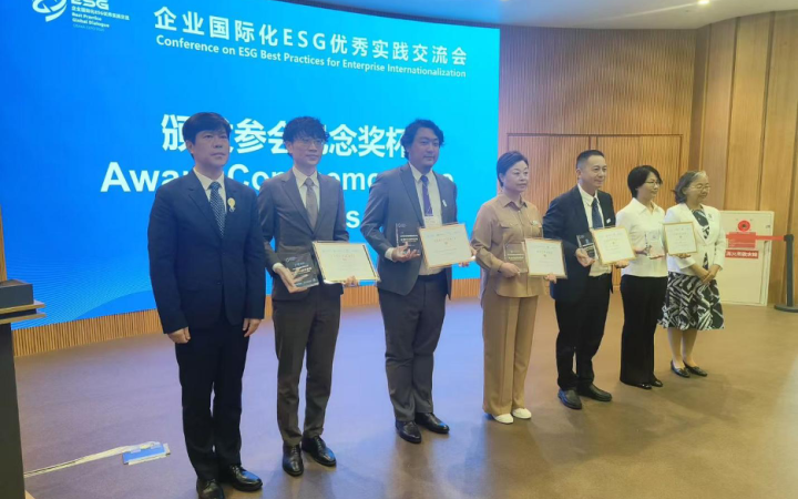 A group photo with several members holding a plaque and award