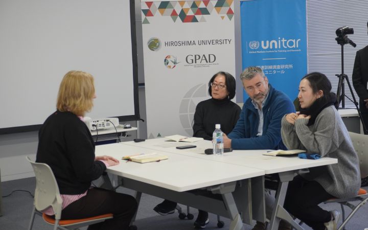 A group of four people conducting a mock interview around a white table.