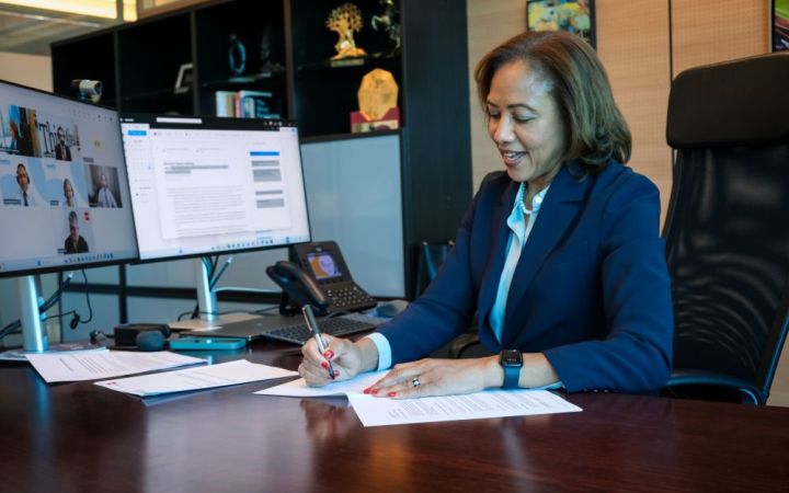 UNITAR Executive Director signing a Memorandum of Understanding in her office during an online signing ceremony