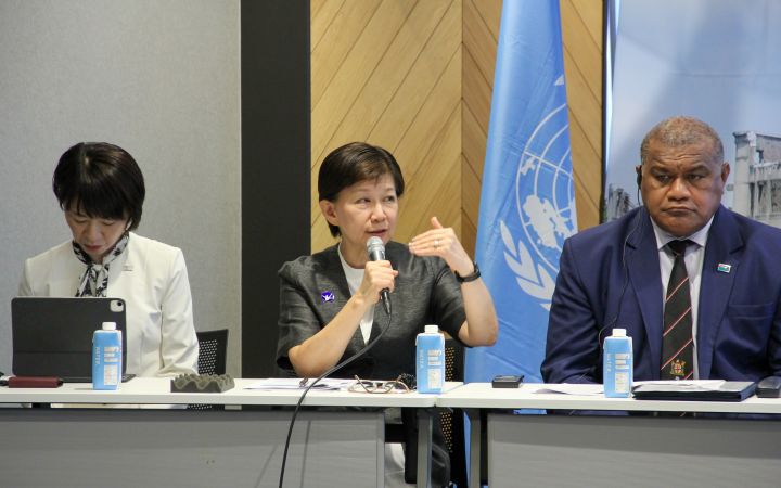 Ms. Izumi Nakamitsu, United Nations Under-Secretary-General and High Representative for Disarmament Affairs speaking through a microphone to young participants
