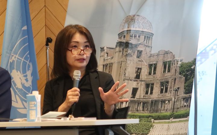Professor Kazuko Hikawa, Professor and Deputy Director of the Research Center for Nuclear Weapons Abolition, Nagasaki University (RECNA) speaking through a microphone to young participants