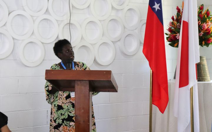 Programme Participant - UNITAR Women's Leadership in Tsunami-based Disaster Risk Reduction Training Programme for World Tsunami Awareness Day A participant standing in front of a brown podium speaking to the audience