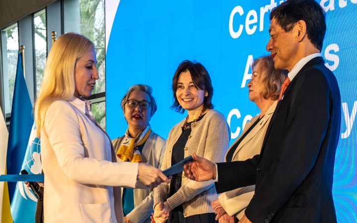 Ukrainian woman receiving a certificate from esteemed guests