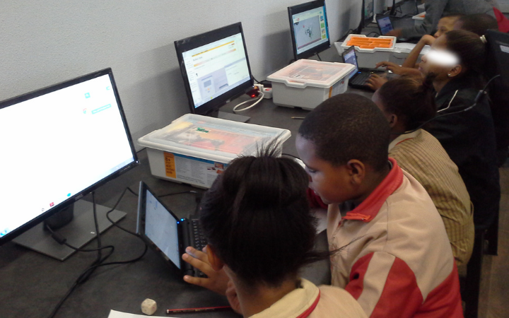 African students seated beside each other facing laptops