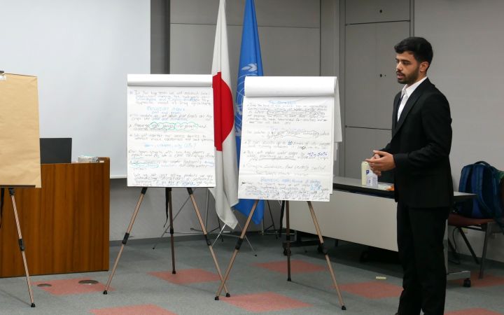 A person conducting a presentation in a room with two supporting panels