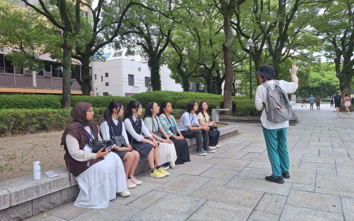  UNITAR “SDGs and the Digital Future" training participants sitting at the Hiroshima Peace Memorial Museum, listening to a lecture