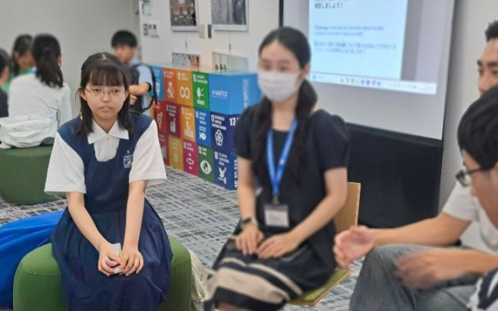 A group of students and staff sitting in a circle for a group discussion