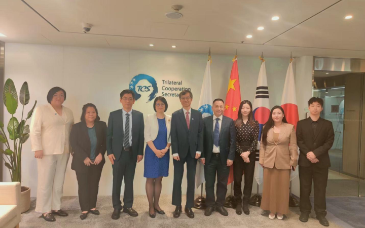 9 members standing in front of the camera at the Trilateral Cooperation Secretariat Visit