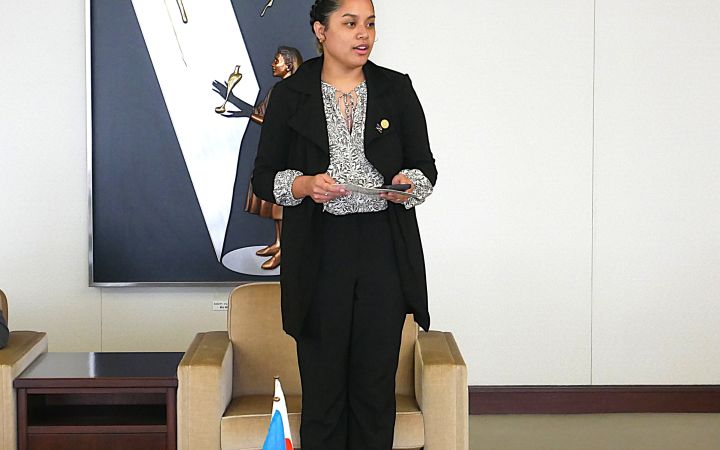 A participant standing in a room to speak to the audience