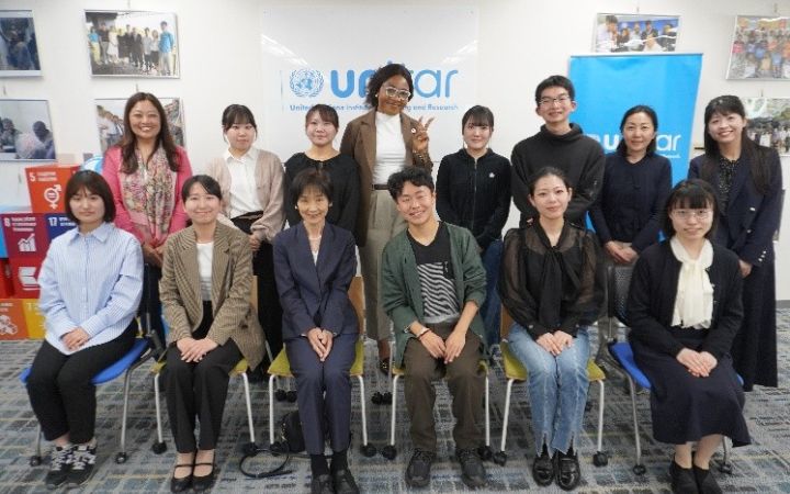 14 participants taking a group image in an office for the UNITAR Hiroshima Youth Ambassador Programme