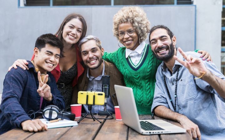 5 people sitting with their arms around the shoulders posing with smiles