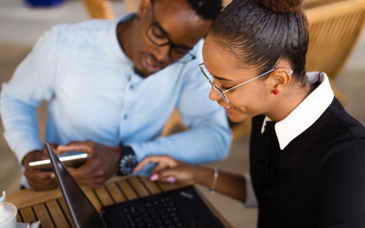 African man and woman looking at a laptop