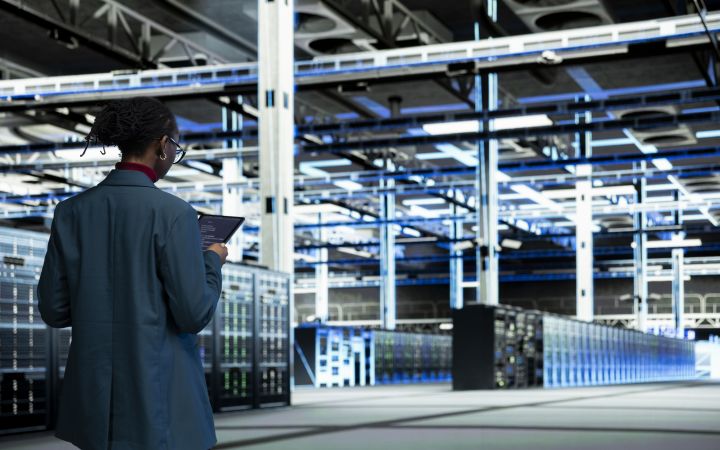 Inside a data center with a computer scientist coding on a tablet