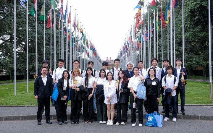 Youth from different countries lined up in front of flags outside