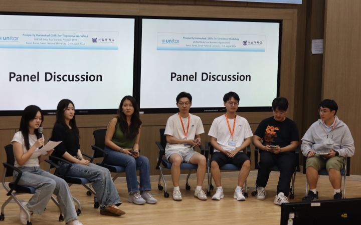 Participants sit and join the panel discussion.