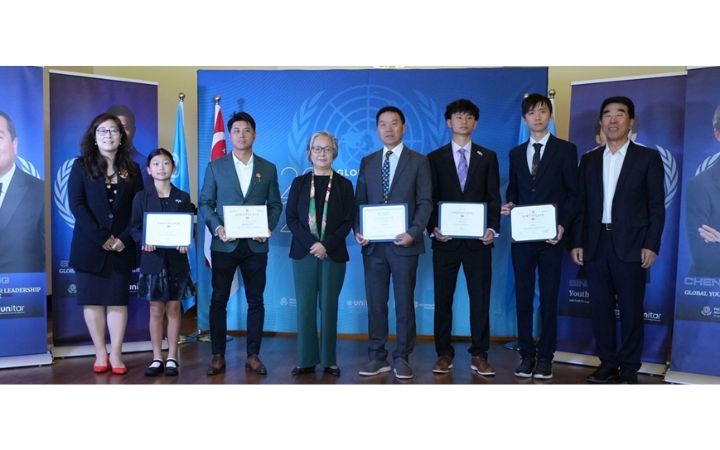 Alt text: Five East Asians including a young girl and young men hold their award certificates and stand with three more mature East Asian women and man. 